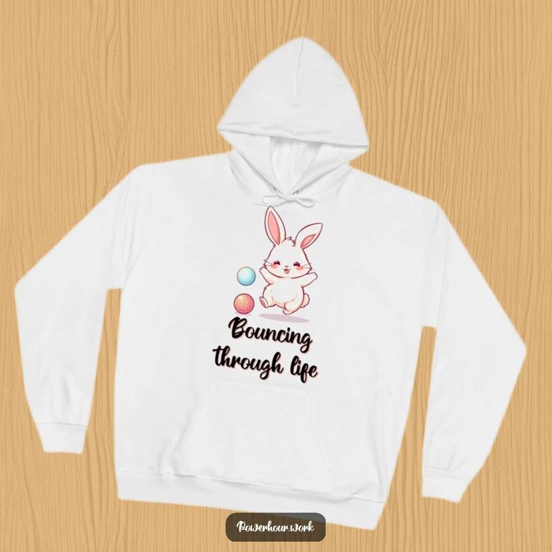 Funny hoodie featuring a fluffy bunny rabbit energetically bouncing a sparkly ball, capturing a moment of joyful, active play.